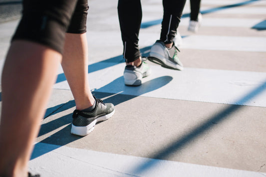 Persone che praticano camminata veloce su strada, con scarpe sportive e passo sostenuto