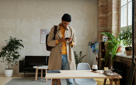 Ragazzo che porta uno zaino e guarda il cellulare 